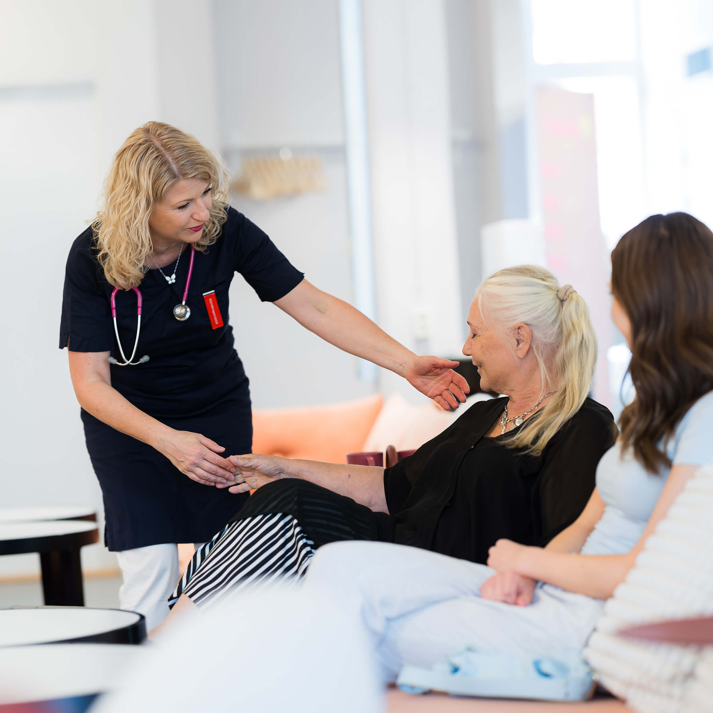 En läkare hjälper en patient upp ur soffan